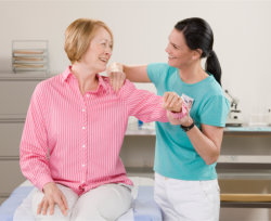 staff assisting her patient in exercise